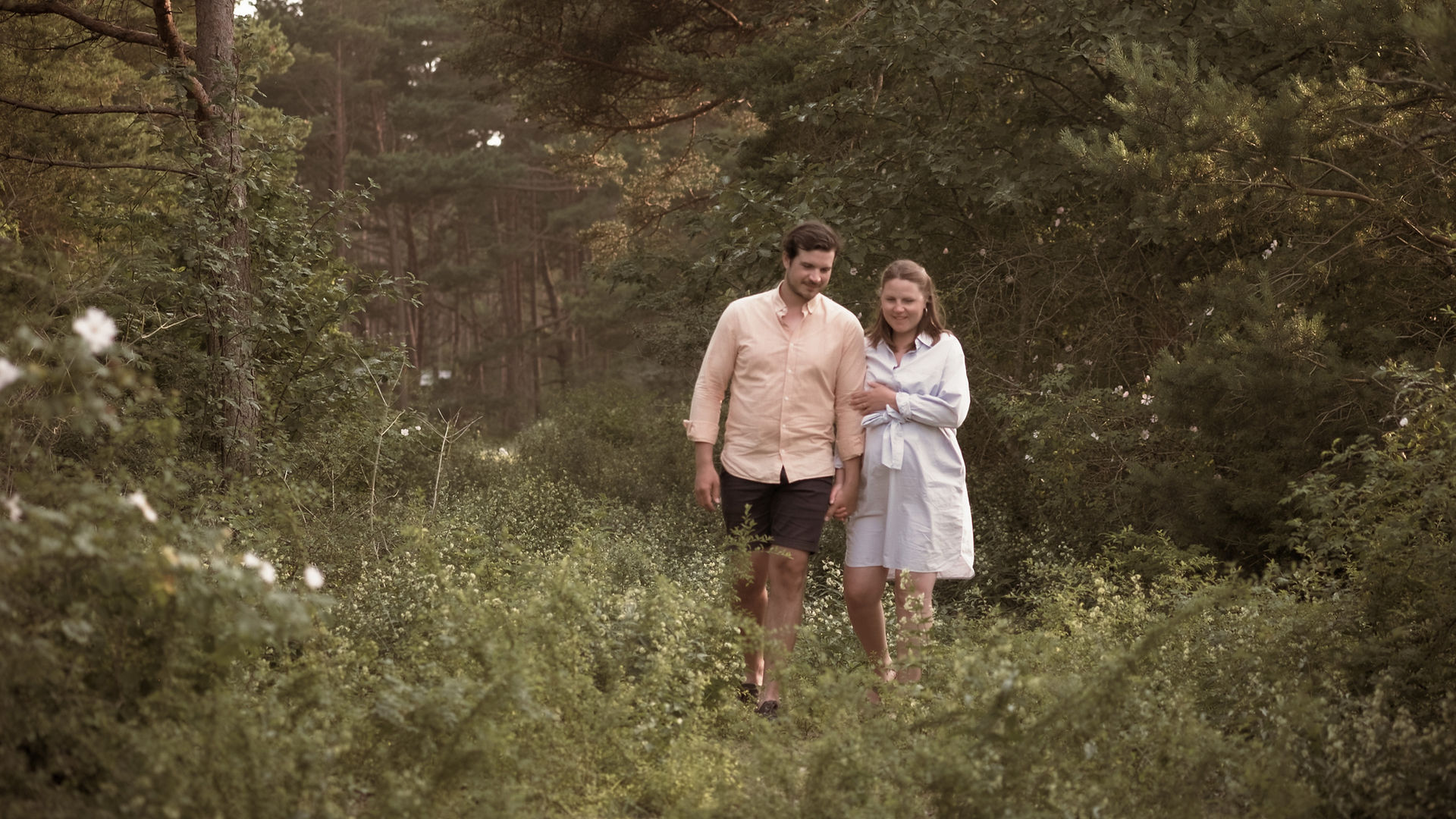A couple walking together through a forest